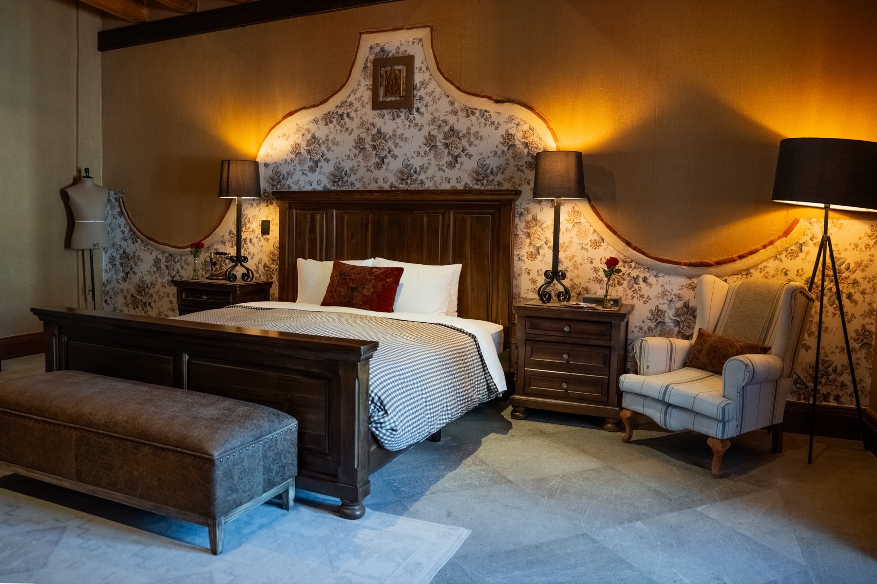 Recámara amplia con tapiz floral y sillón de rayas